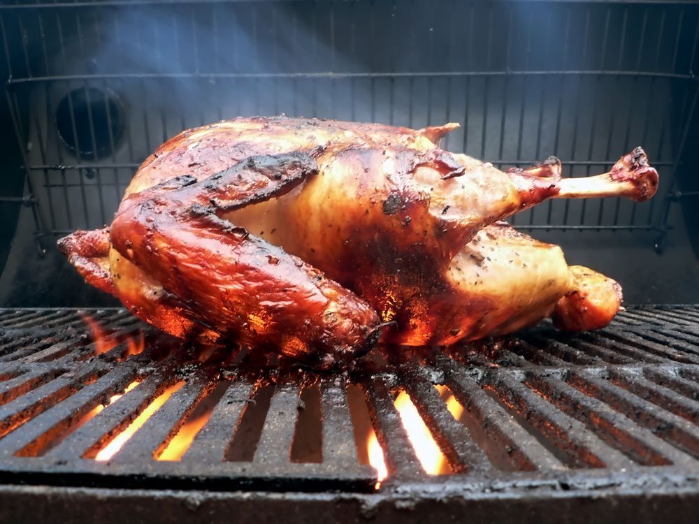 Close-up of a turkey cooking on a grill.
