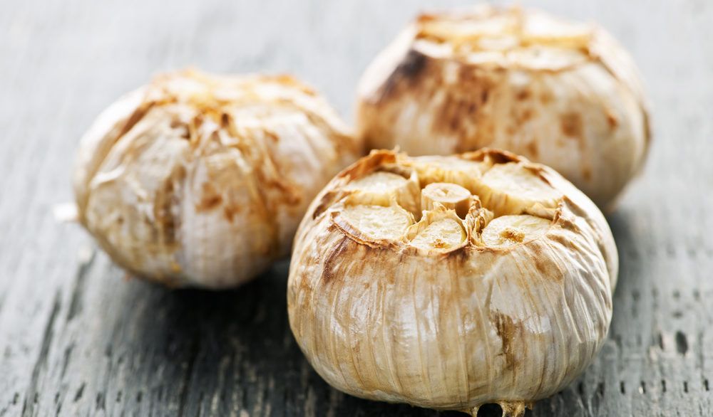 Close-up of three cloves of roasted garlic.
