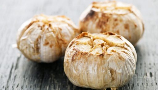 Close-up of three cloves of roasted garlic.