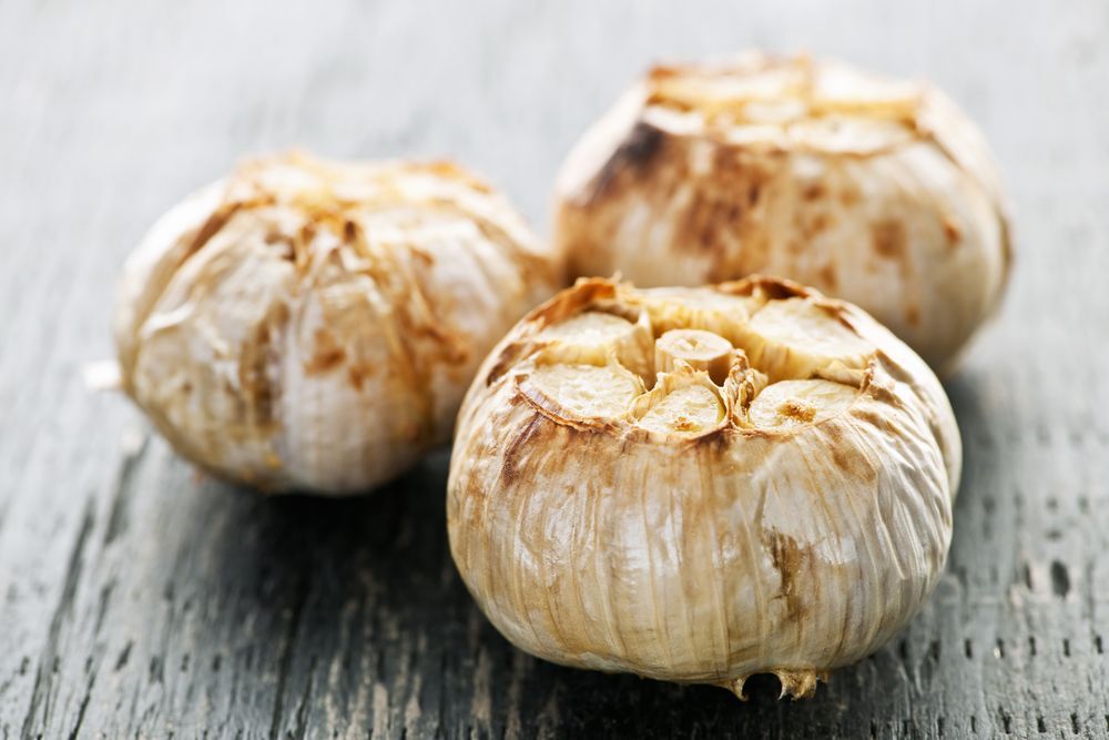 Close-up of three cloves of roasted garlic.