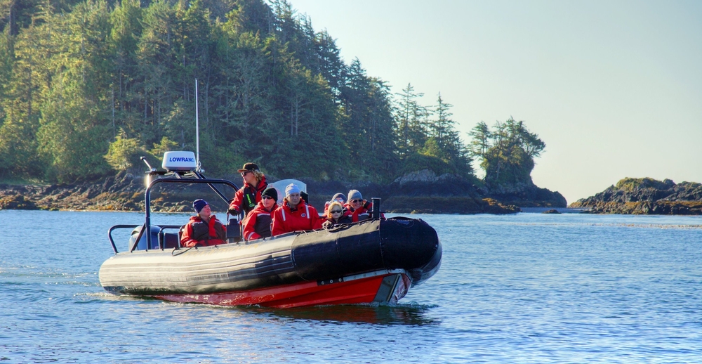 A group of whale watchers in a red boat in Tofino, British Columbia.