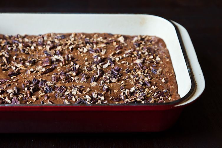 brownies in a pan with nuts on top
