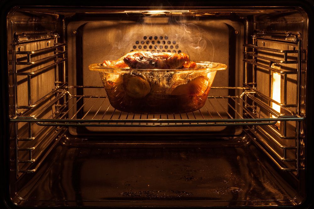 A chicken roasting in an oven.