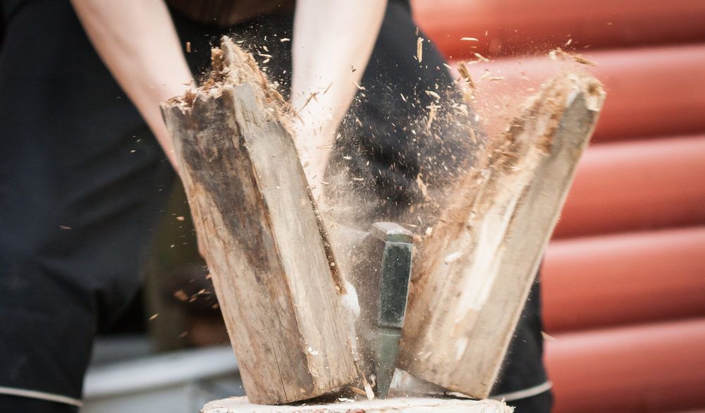 Close-up of a person splitting firewood.