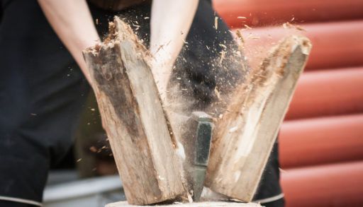 Close-up of a person splitting firewood.