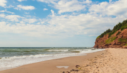 A beach with red cliffs at Basin Head, Prince Edward Island.