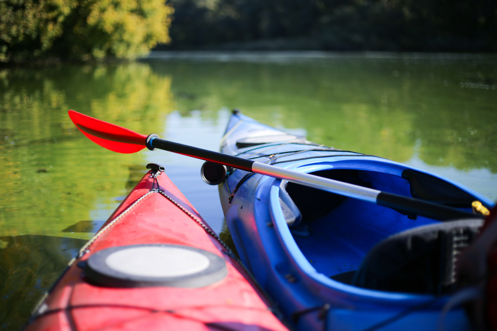 Close-up of the fronts of red and blue kayaks.