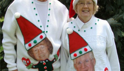 An older couple in matching sweaters portraying each other as elves