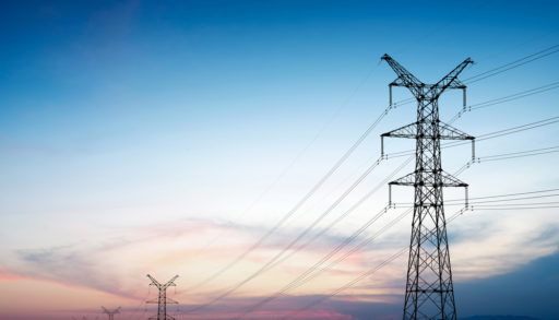 Silhouettes of power lines during sunset.