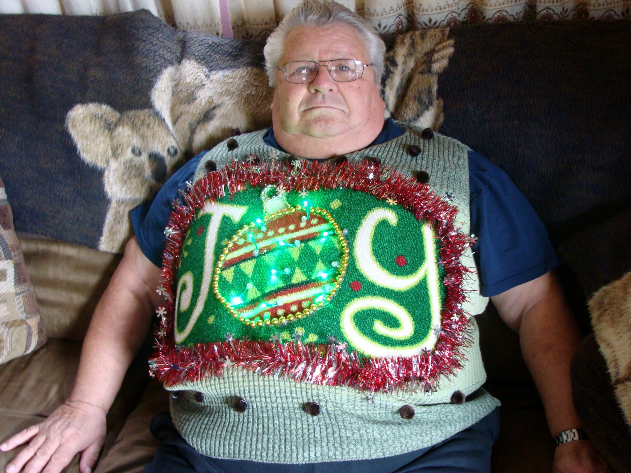 Man in ugly sweater reading "Joy"