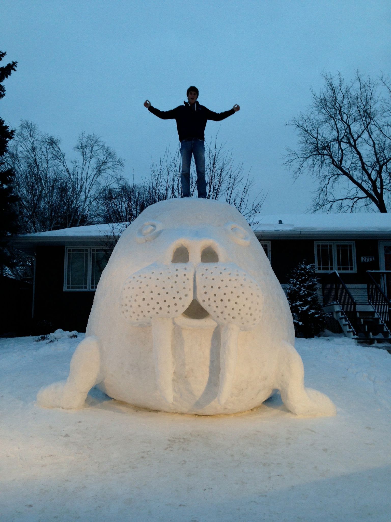 Man standing on a giant snow walrus