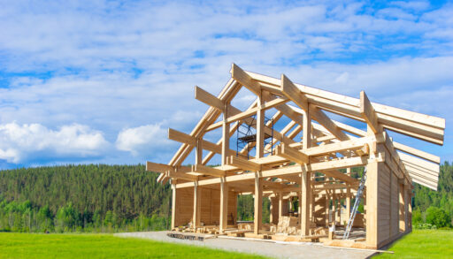 Framing of a house in a grassy field.