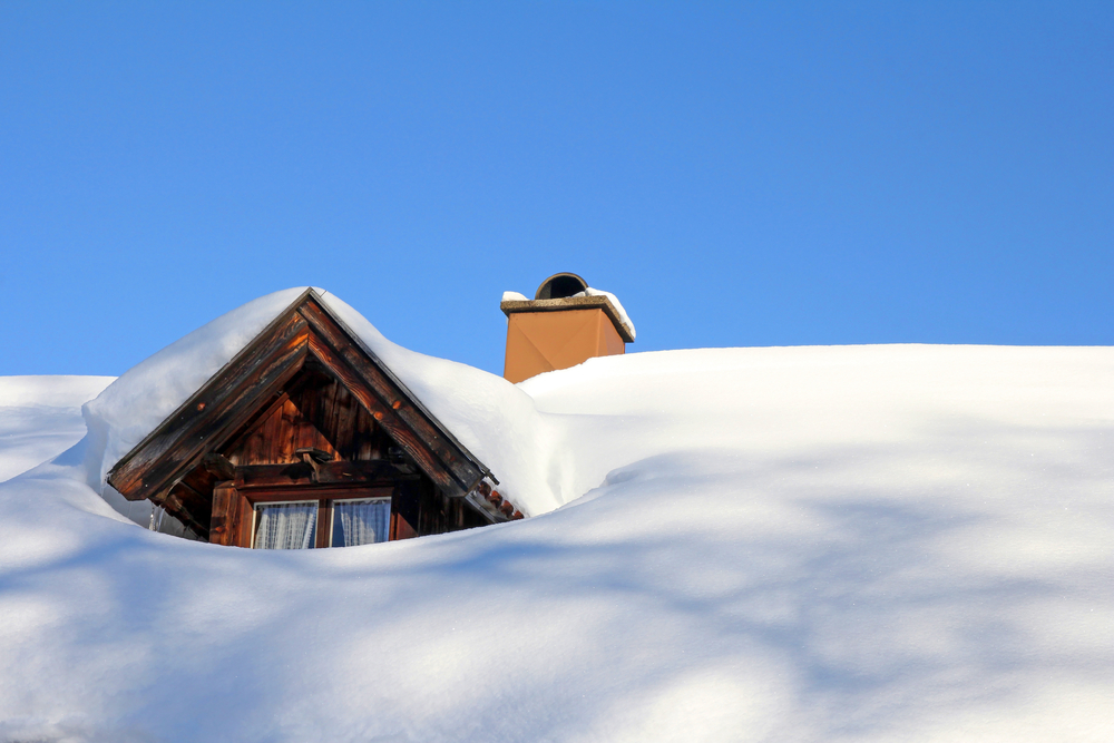 A snow-covered roof of a wooden house