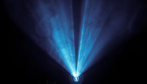 Movie projector creating blue light in a dark room.