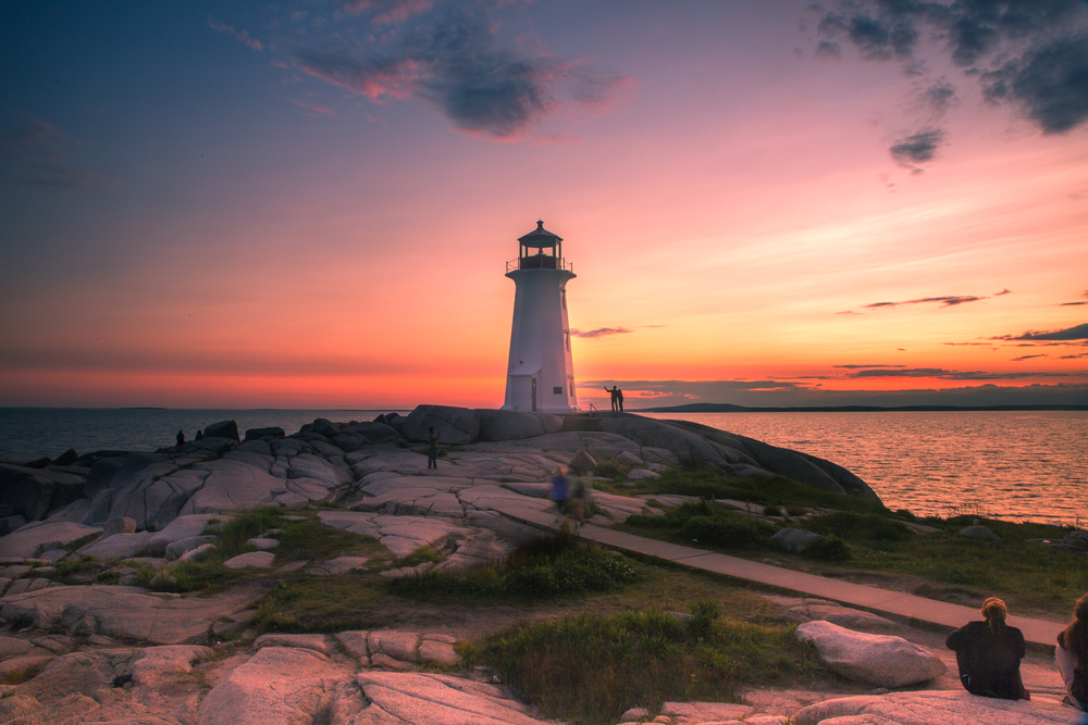 Lighthouse on rock formation at sunset. Peggy's Cove, Nova Scotia.