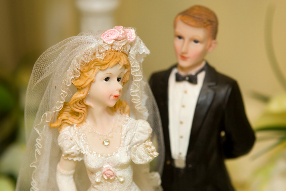 Close-up of bride and groom cake toppers.