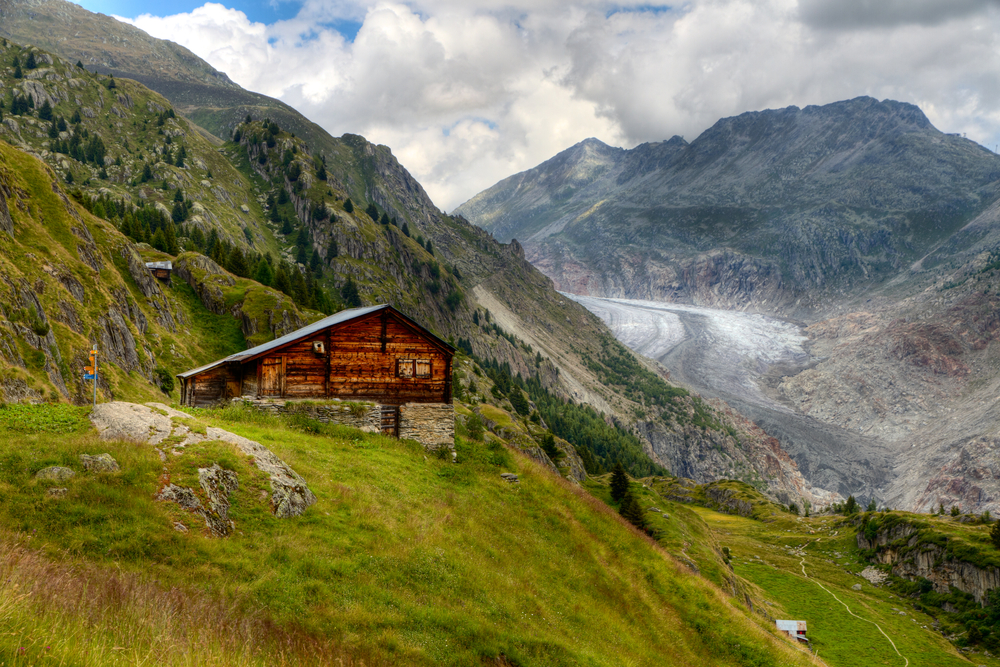 Wooden cabin nestled in a mountain in the fall season.