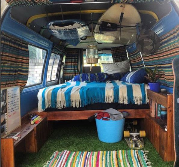 Interior of van with bed and surfboards