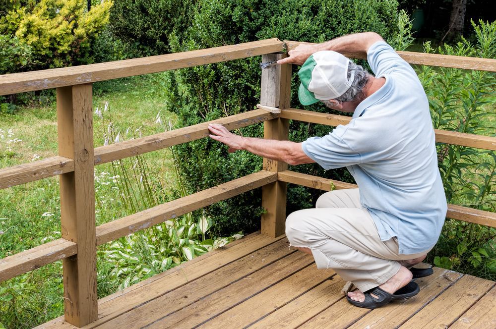An older man working on a deck.