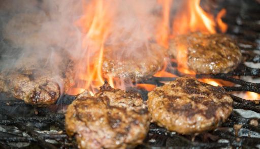 Close-up of hamburgers being grilled on a barbecue.