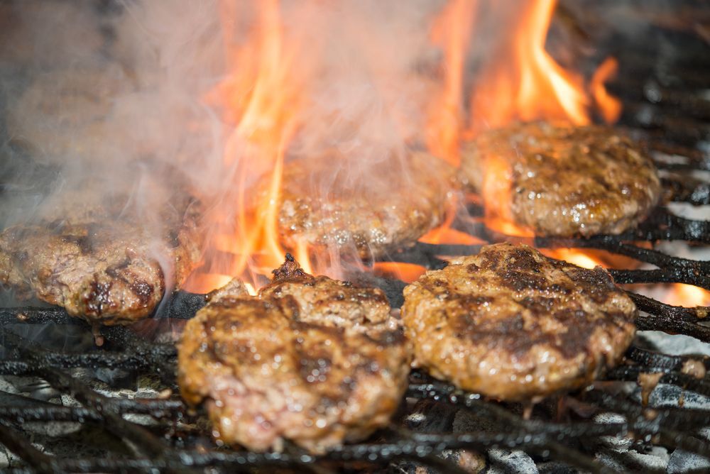 Close-up of hamburgers being grilled on a barbecue.