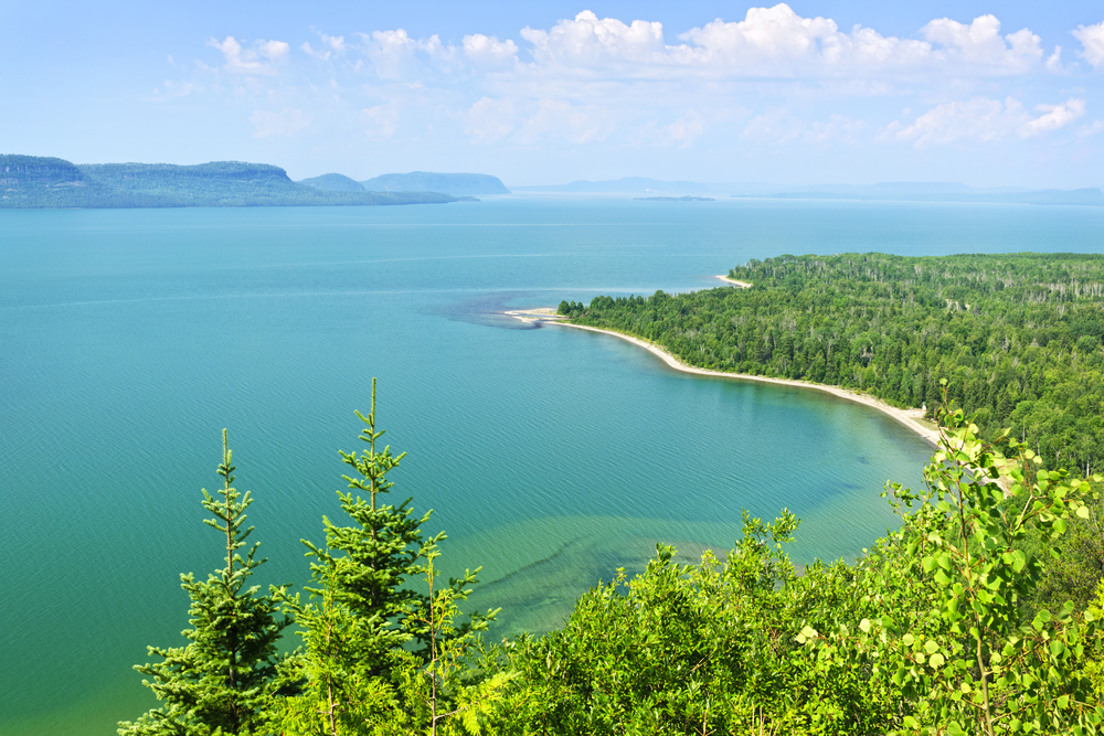 View of Lake Superior from above lined with a forest landscape.