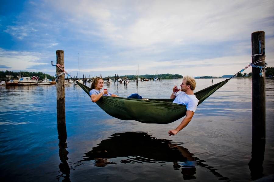 A hammock between two posts over blue water