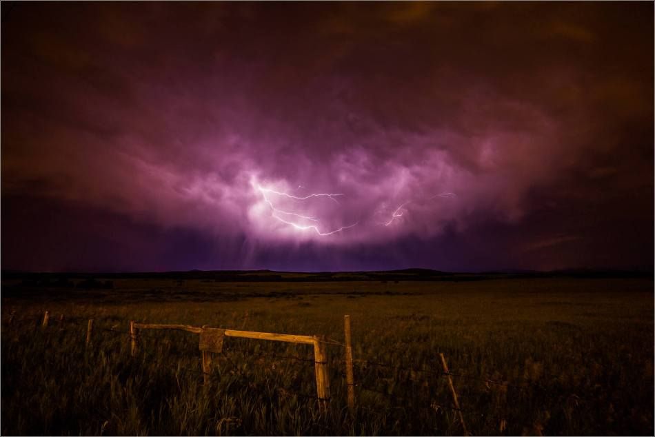 Purple lightning over a field