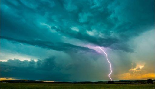 Lightning over a green field