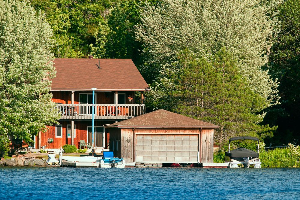Cabin nestled in a forest overlooking a lake.