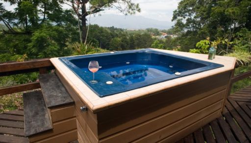 Hot tub on a deck surrounded by trees.