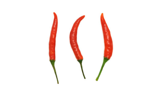 Three red chili peppers isolated on a white background.