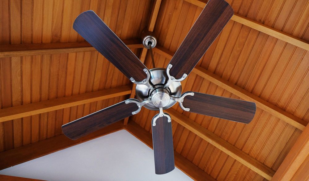 Cottage ceiling fan attached to a wooden A-frame roof.