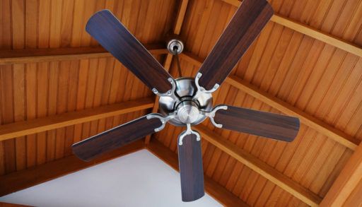 Cottage ceiling fan attached to a wooden A-frame roof.