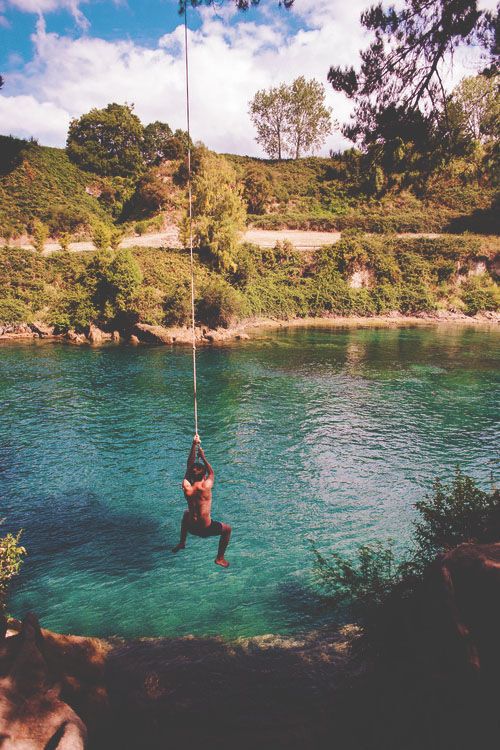 Man swinging into large body of water