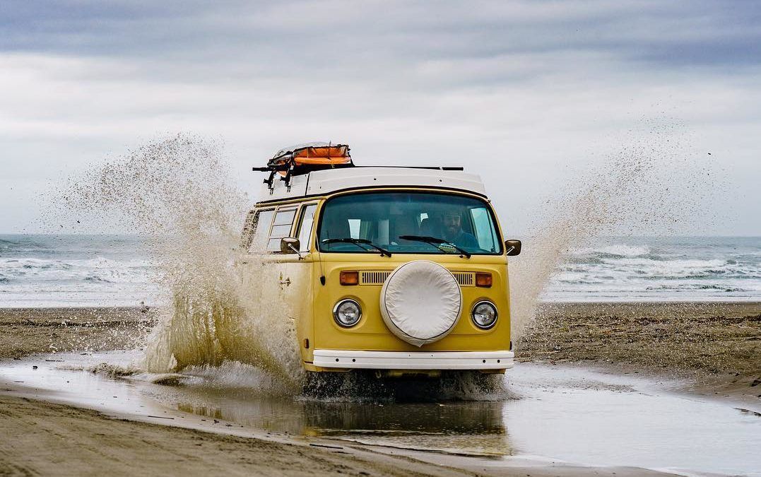 VW van driving on the beach