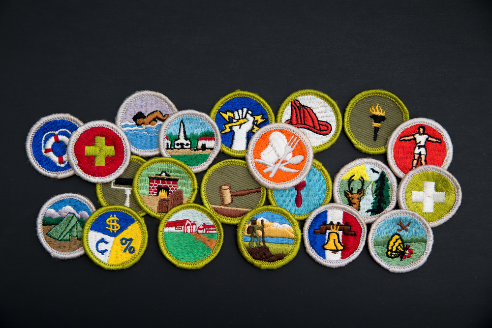 A pile of brightly coloured merit badges on a black background.