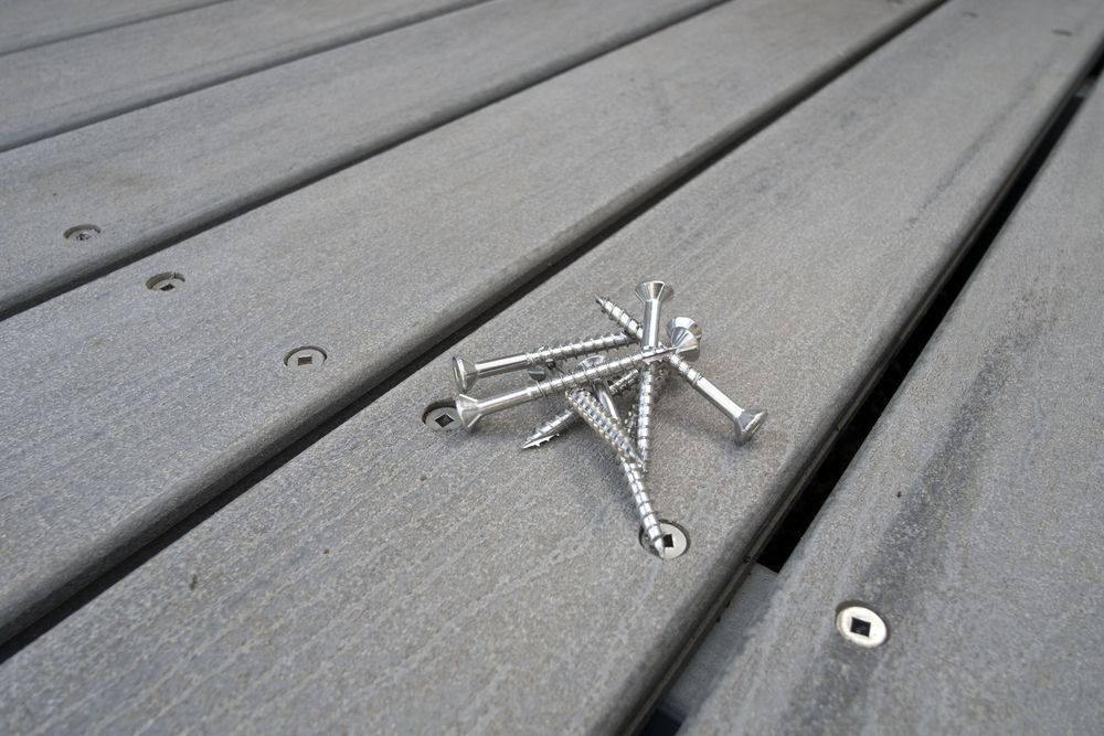 Pile of nails sitting on a grey deck.