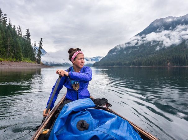 cat in woman's coat as she kayaks