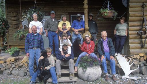 A family all gathered on a wooden front porch for a photo.
