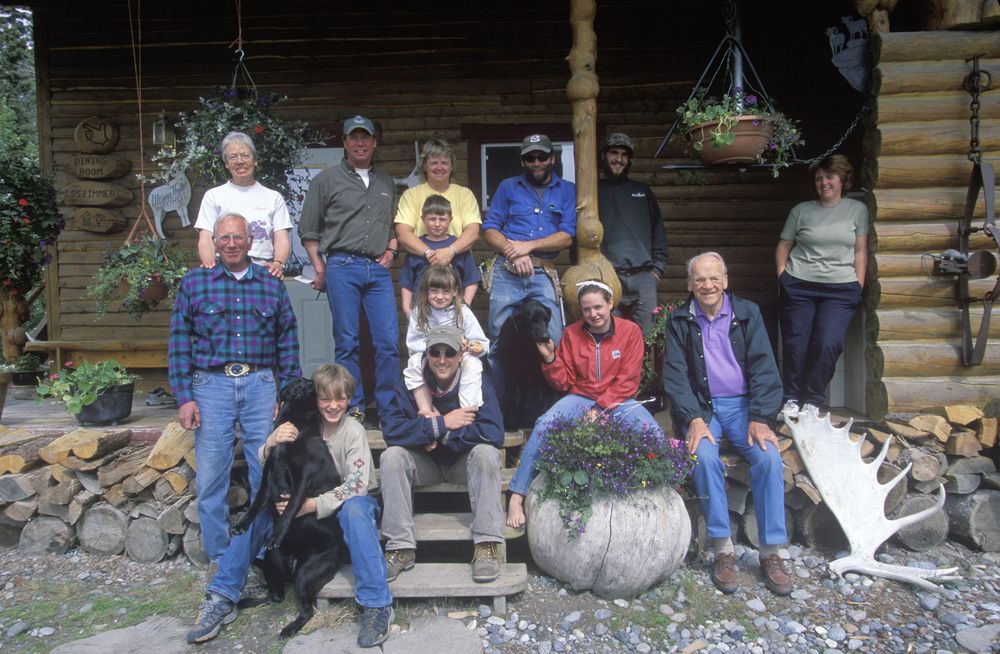 A family all gathered on a wooden front porch for a photo.
