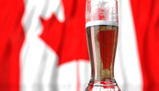 Glass of beer in front of a Canadian flag.