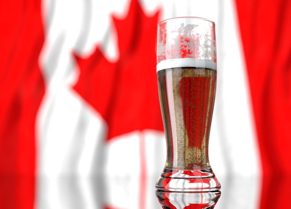 Glass of beer in front of a Canadian flag.