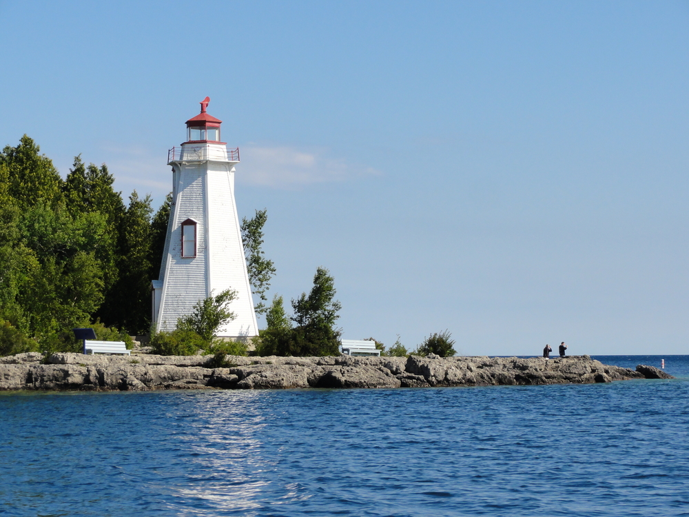 White and red lighthouse looking out over the water.