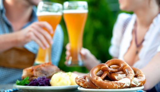 Couple having beer and a traditional Oktoberfest meal during Oktoberfest.