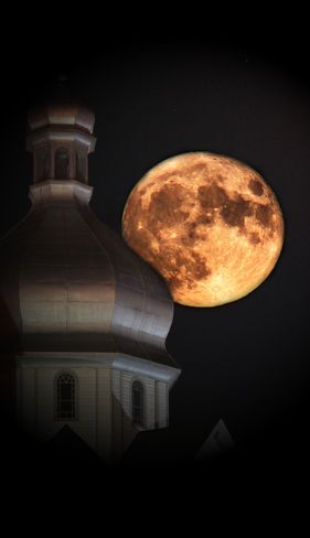 Big moon behind a building