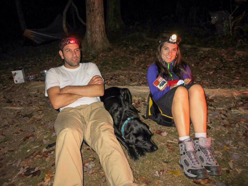Couple camping in dark with subtle bear lurking in background
