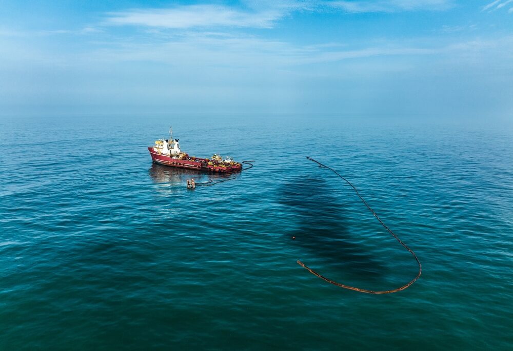 Ship trying to contain an oil spill in the ocean.