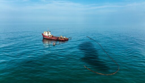 Ship trying to contain an oil spill in the ocean.
