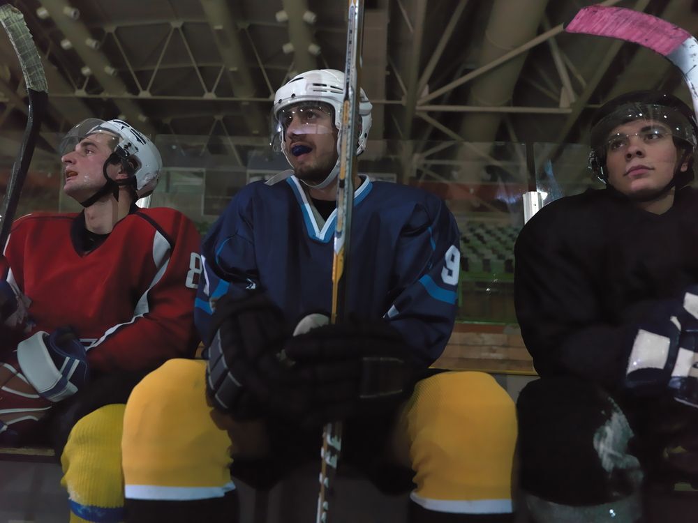 Hockey players sitting on the bench.